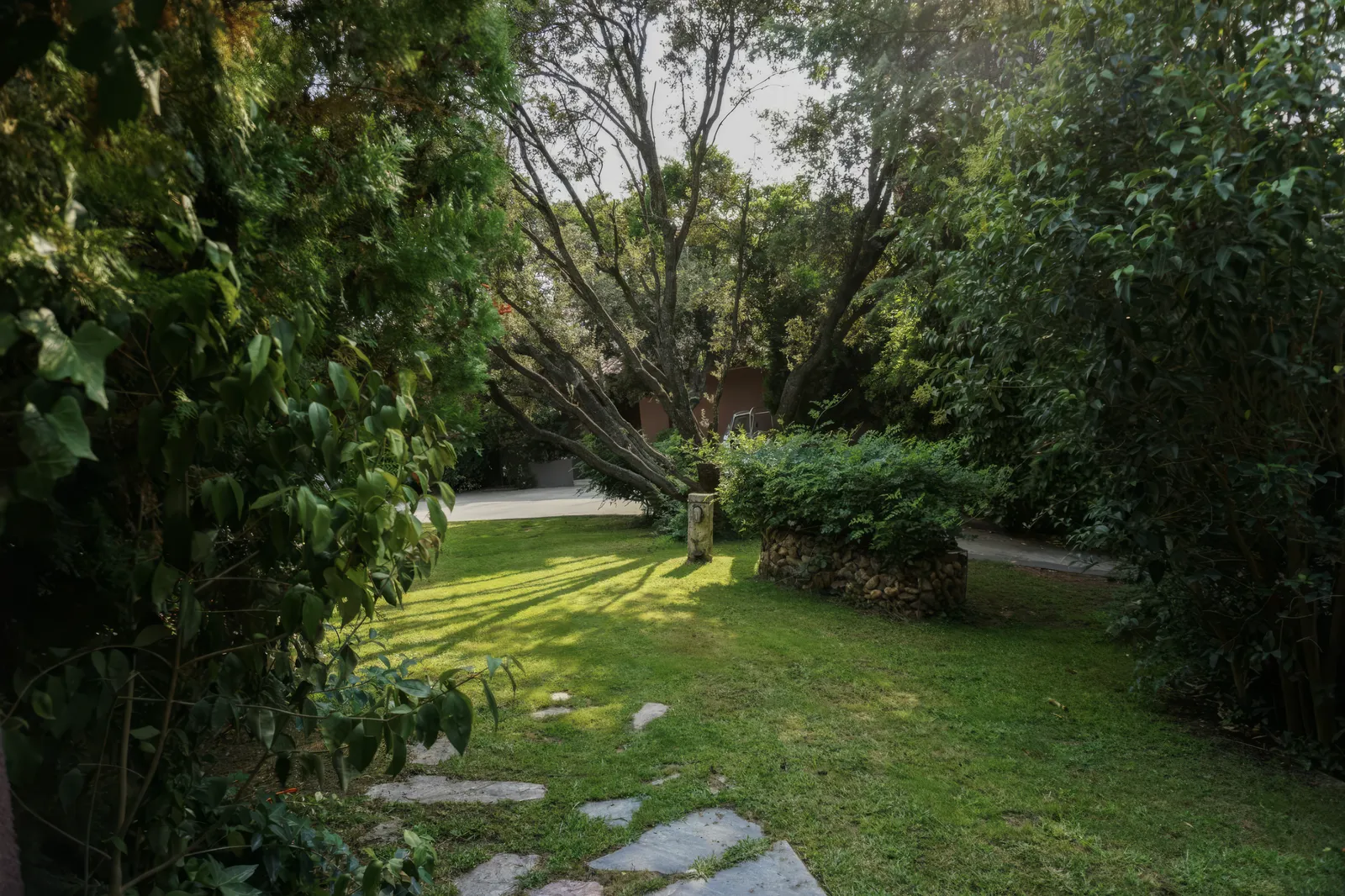 Jardín con césped y árboles centenarios